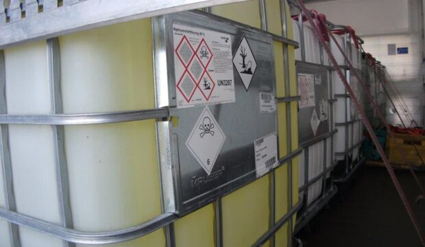 An IBC with chemical liquid and hazardous goods labelling secured on a euro.COURIER truck