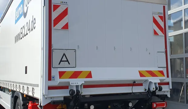 LKW mit aufgeklappter Warntafel fuer Abfalltransporte.